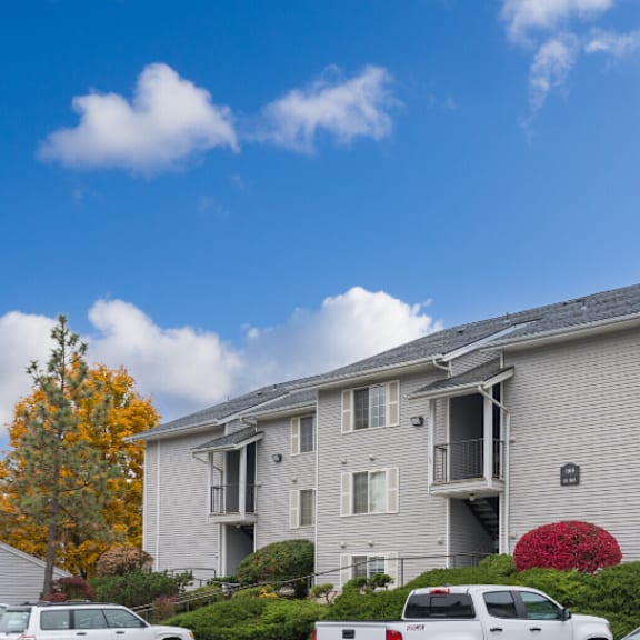 the view of an apartment building with cars parked in front of it