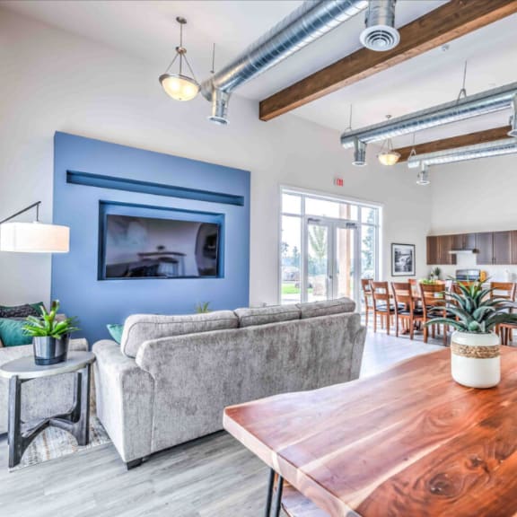 a modern living room with a wooden table and a grey couch.