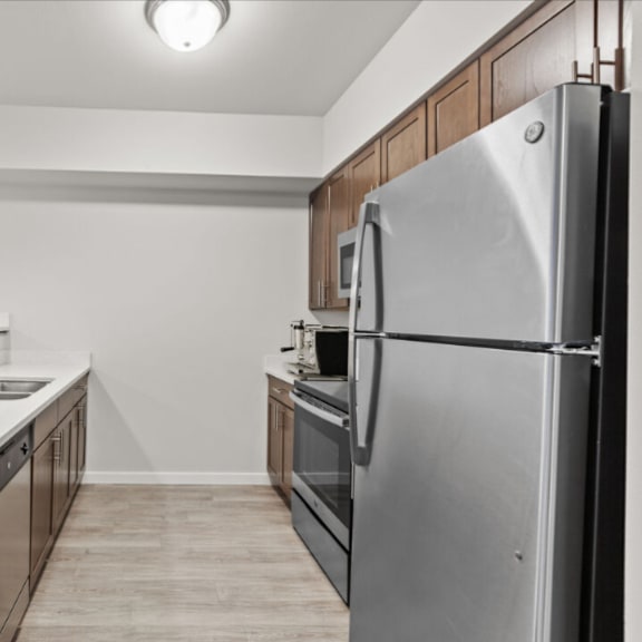 a modern kitchen with a refrigerator on the right side.