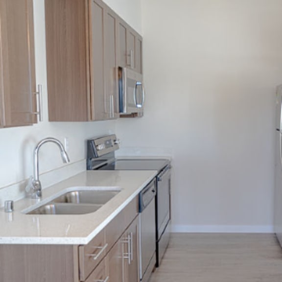 a kitchen with a sink, refrigerator, and microwave.