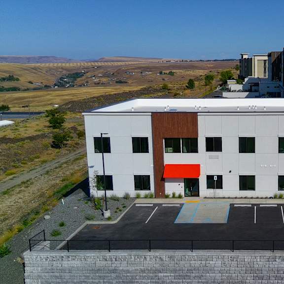 a modern building with a parking lot in front.