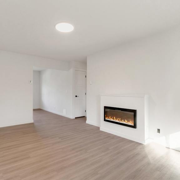 a living room with white walls and a fireplace