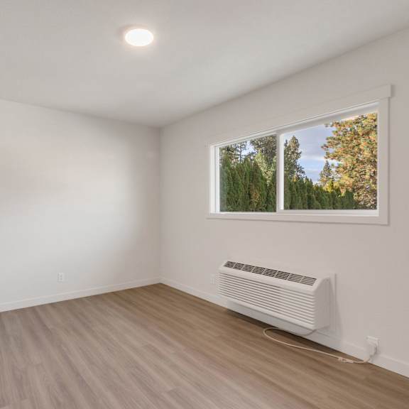 an empty room with white walls and a window