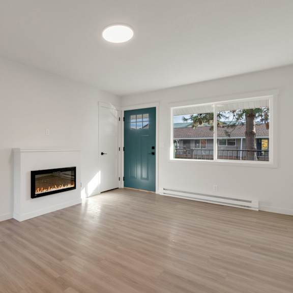 a living room with a fireplace and a door into a hallway