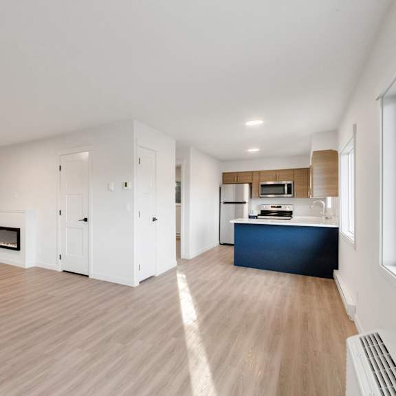an empty living room and kitchen in a new home