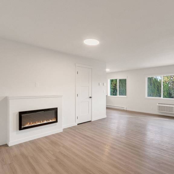 an empty living room with a fireplace and a window