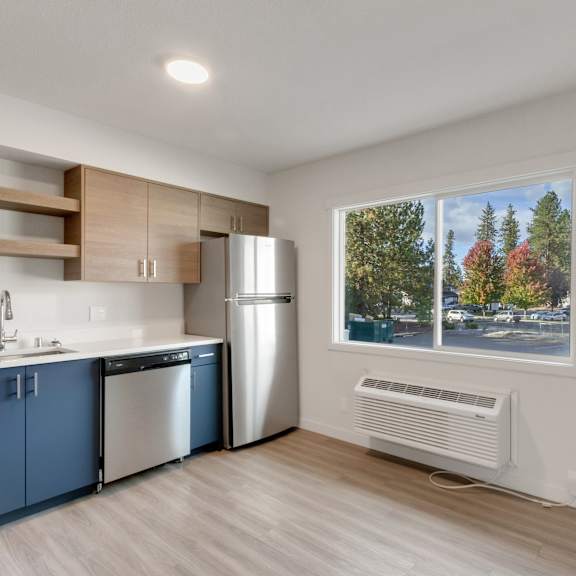 a kitchen with a large window and a sink and a refrigerator