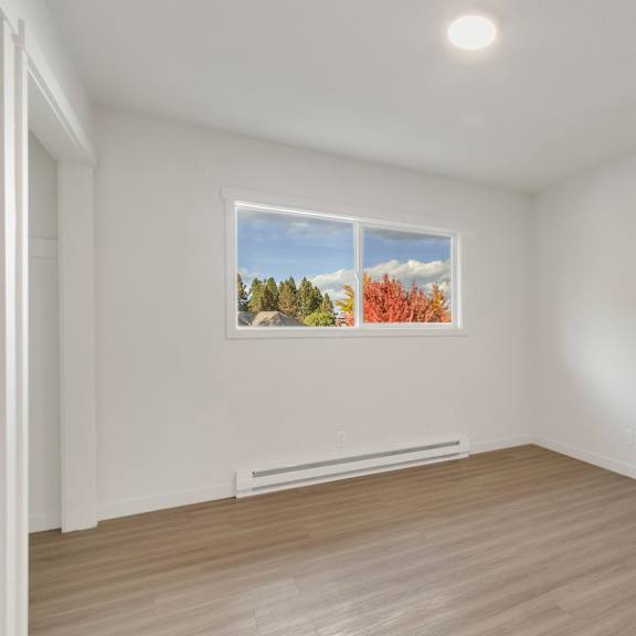 a living room with white walls and a window