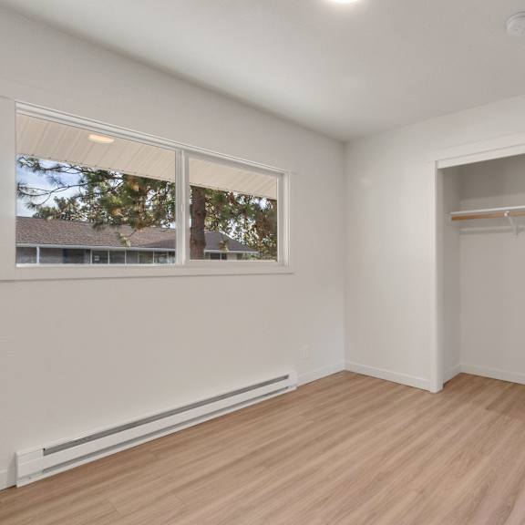 a bedroom with white walls and a white door and a window