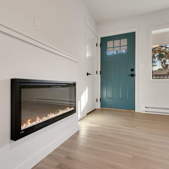 a living room with a fireplace and a blue door