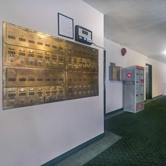 a long hallway with a wall of mailboxes on the left.