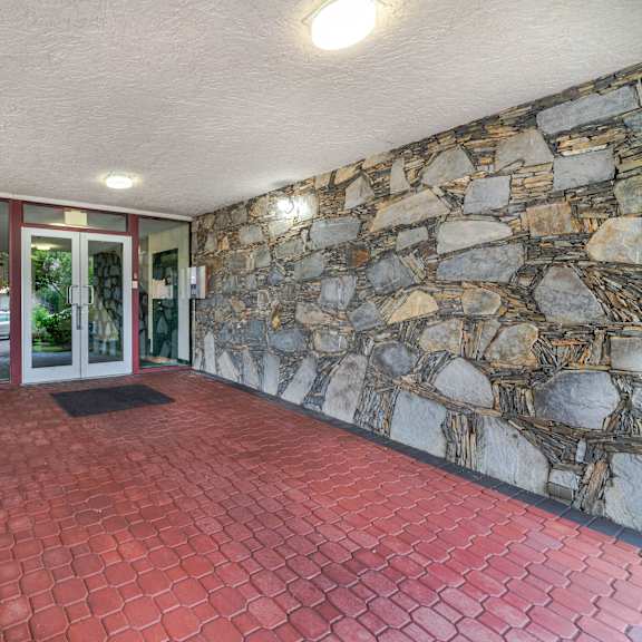 a stone wall with a glass door and windows.