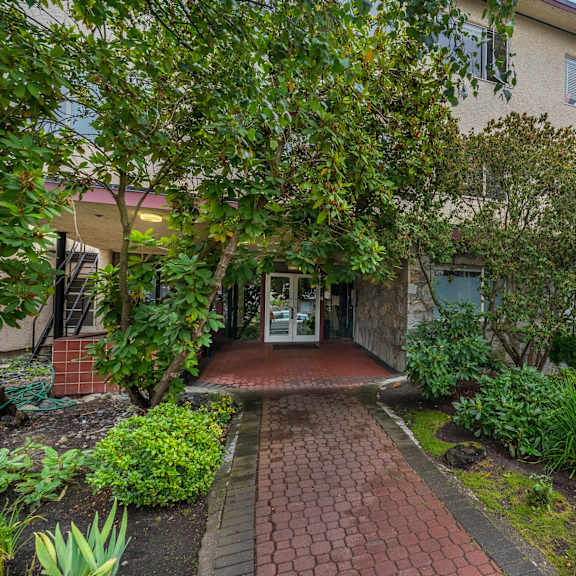a building with a brick pathway leading to the entrance.