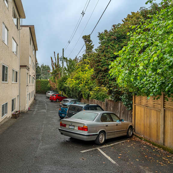 a car is parked on the side of a narrow street.