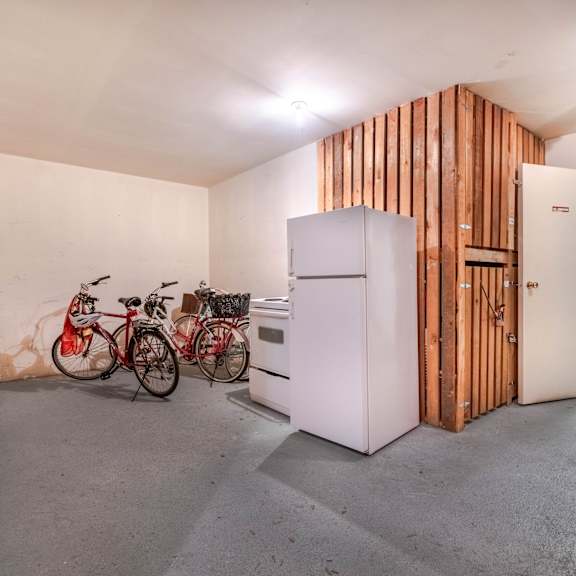 a room with a white fridge and a wooden wall.