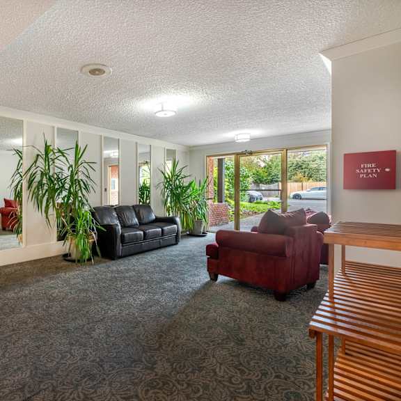 a hallway with a red couch and a wooden bench.