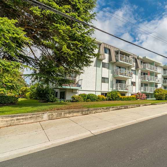 a street view of a residential area with apartment buildings on the side.