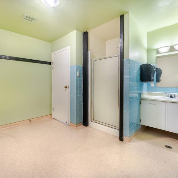 a bathroom with a sink, mirror, and two doors.