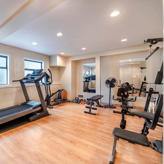 a well-lit home gym with a variety of exercise equipment.