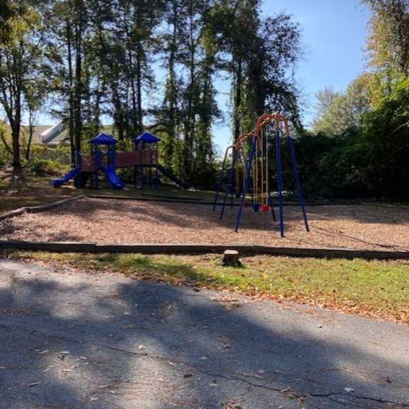 a playground in a park with trees in the background