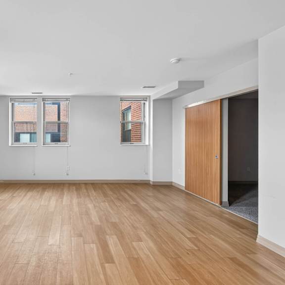 a room with wooden flooring and white walls.