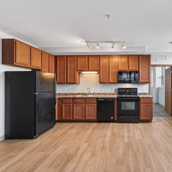 a kitchen with wooden cabinets and black appliances.