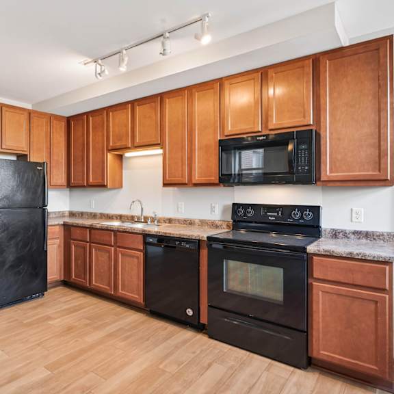 a kitchen with wooden cabinets and black appliances.