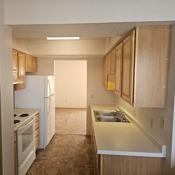 a kitchen with wooden cabinets and a white refrigerator.