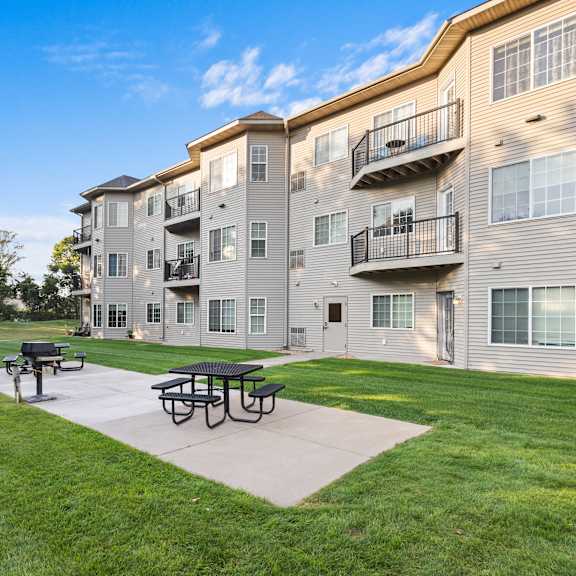 a sunny day at the apartment complex with a picnic table in the foreground.