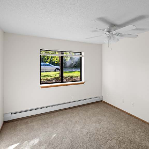 a room with a window and a ceiling fan.