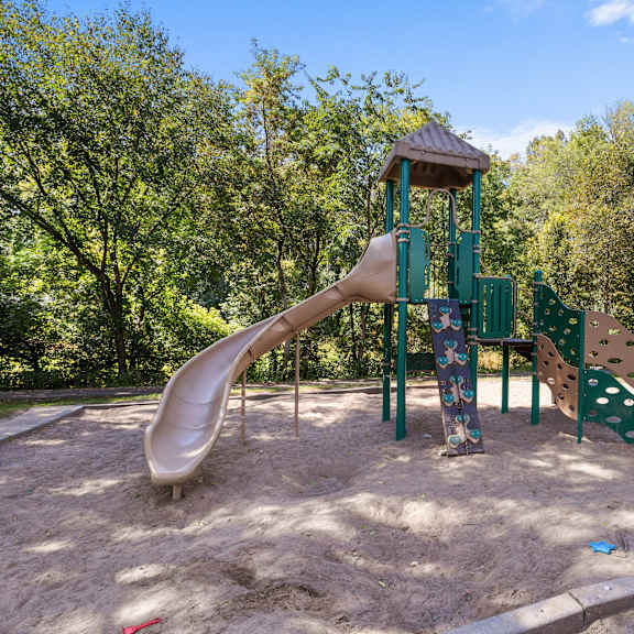 a playground with a slide and a wooden structure.