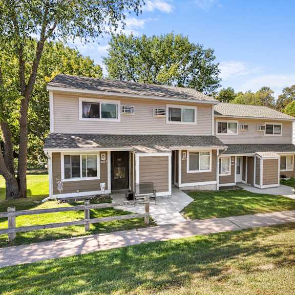 a house with a white picket fence in front.
