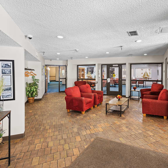 a room with red chairs and a brown rug.