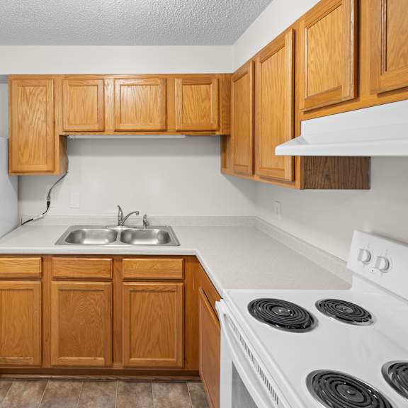 a kitchen with wooden cabinets and white appliances.