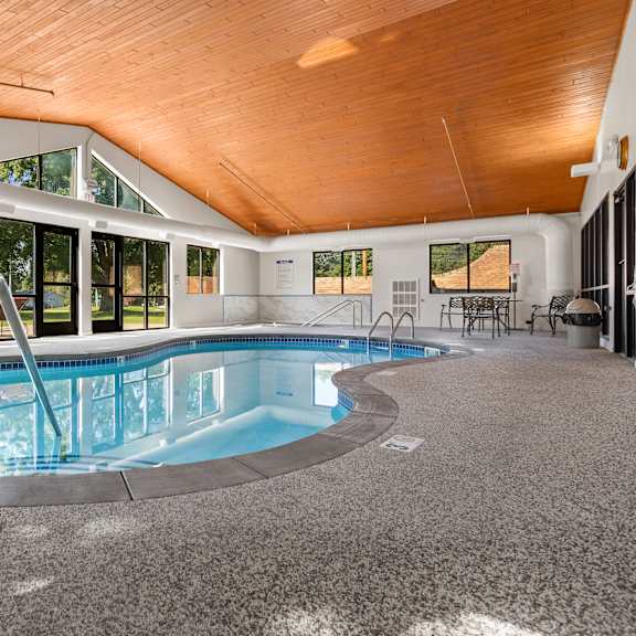 a large indoor swimming pool with a wooden ceiling.