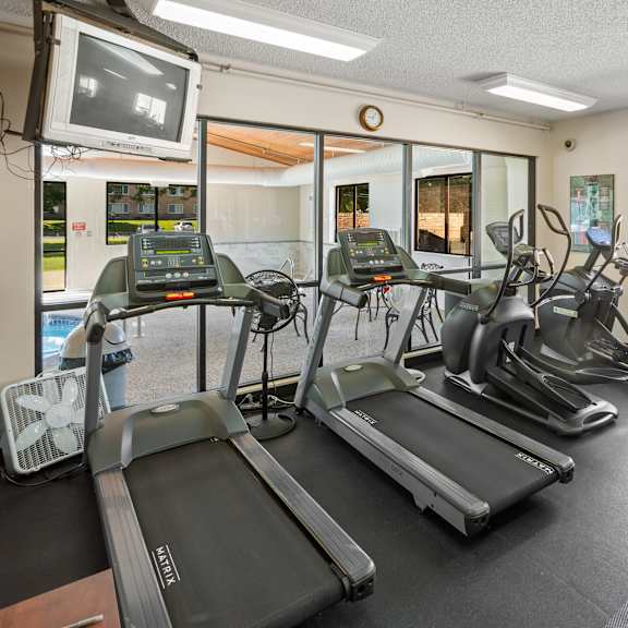 a gym with treadmills, exercise bikes, and other equipment.