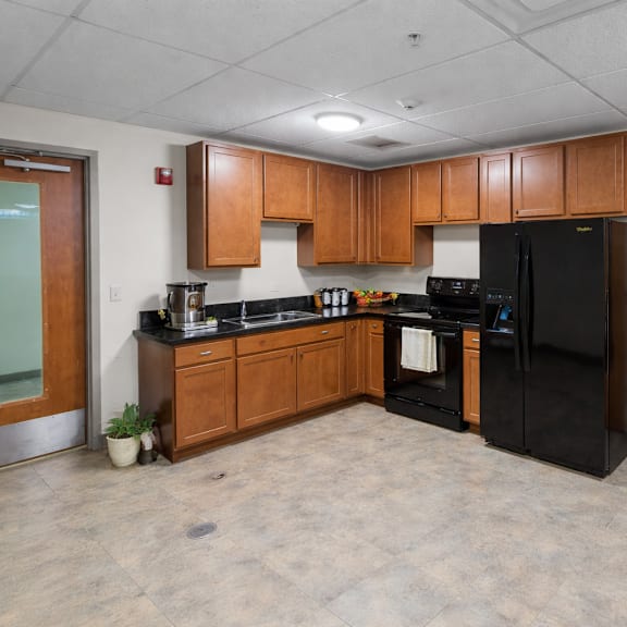 a kitchen with black appliances and wooden cabinets.