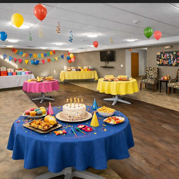 a birthday party with a cake and balloons.