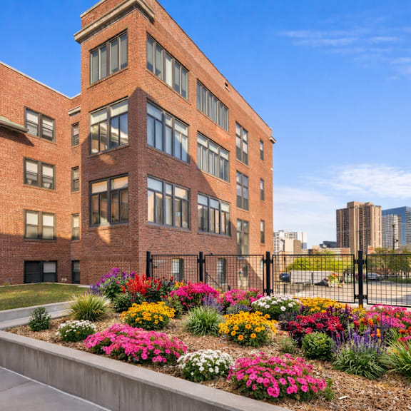 a red brick building with a flower bed in front.