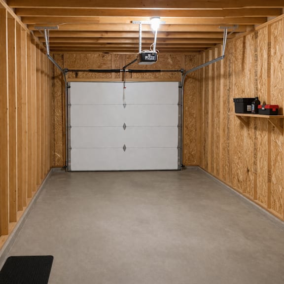 a garage with a white door and a black mat on the floor.