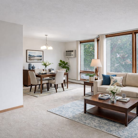 a living room with a couch, coffee table, and dining table.