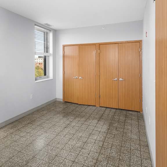 a room with a tiled floor and a window with blinds.