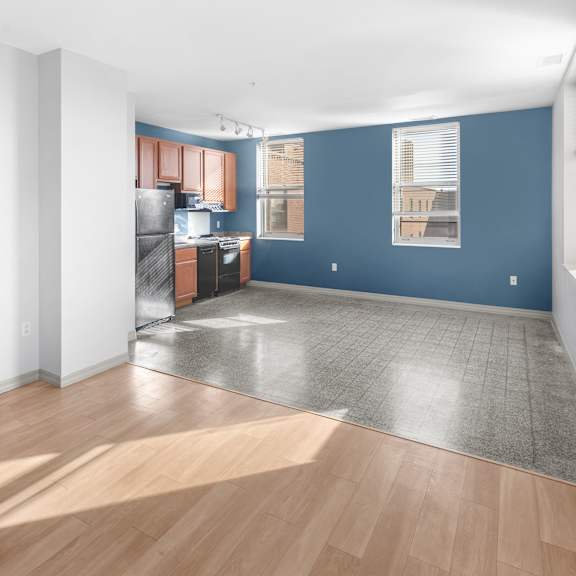 a room with a kitchen area and a dining table.