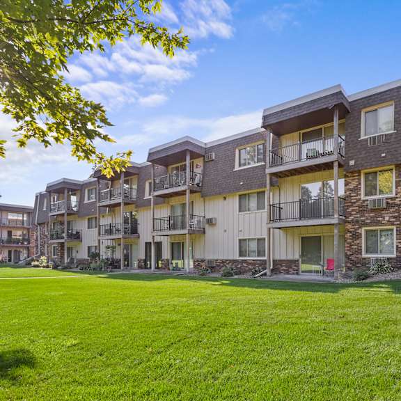 a sunny day at a grassy apartment complex.