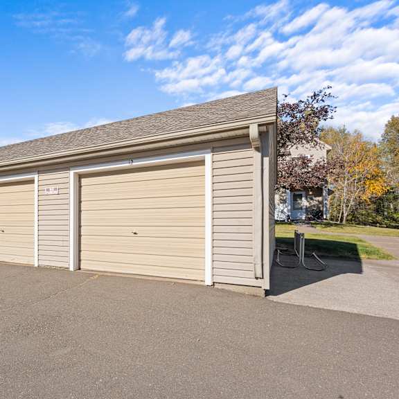a long building with a grey roof and tan garage doors.