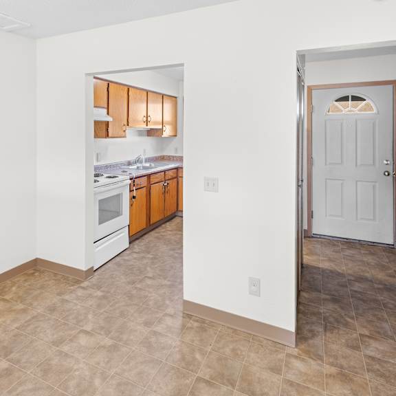 a kitchen with white walls and a tiled floor.