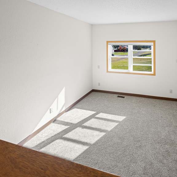 a room with a window and a carpeted floor.