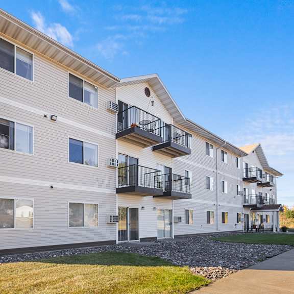 a modern apartment building with balconies and a clear blue sky.