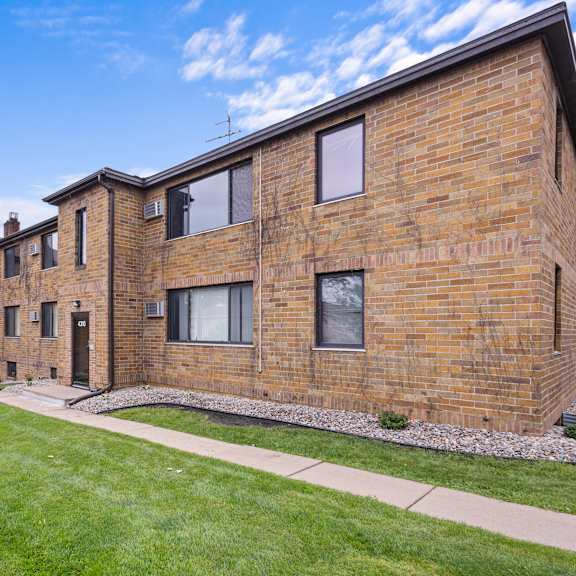 a brick building with a green lawn in front.