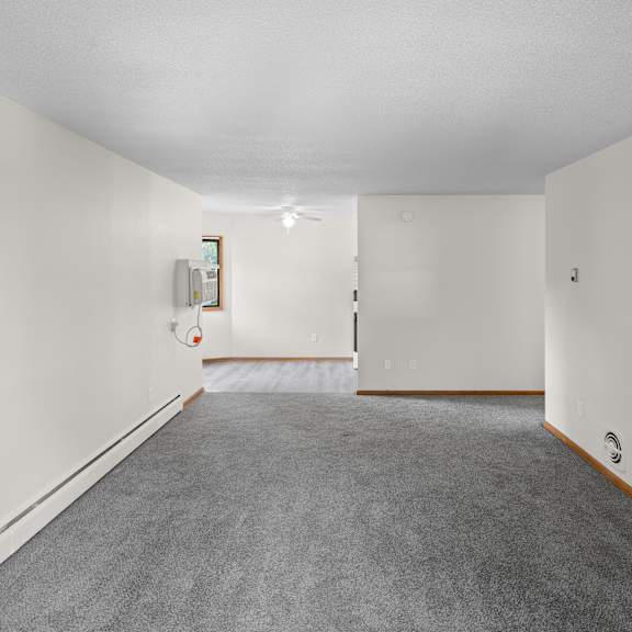 a long hallway with a carpeted floor and white walls.